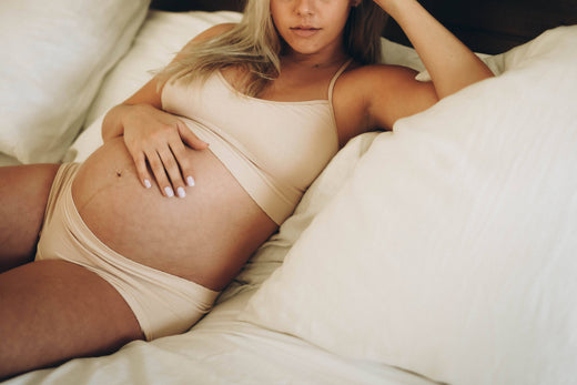 Pregnant woman laying down on the bed