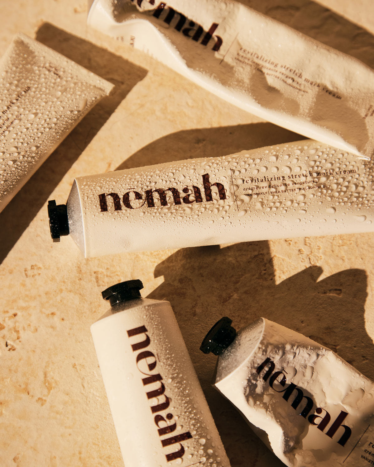 Tubes of Nemah skincare products on a textured surface