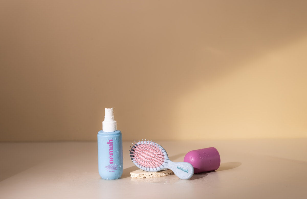 blue spray bottle with a hair brush 