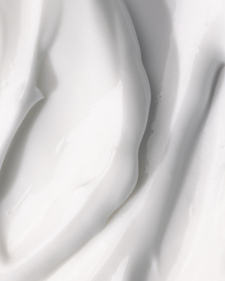Close-up of smooth white cream or lotion texture with soft folds and glossy surface.
