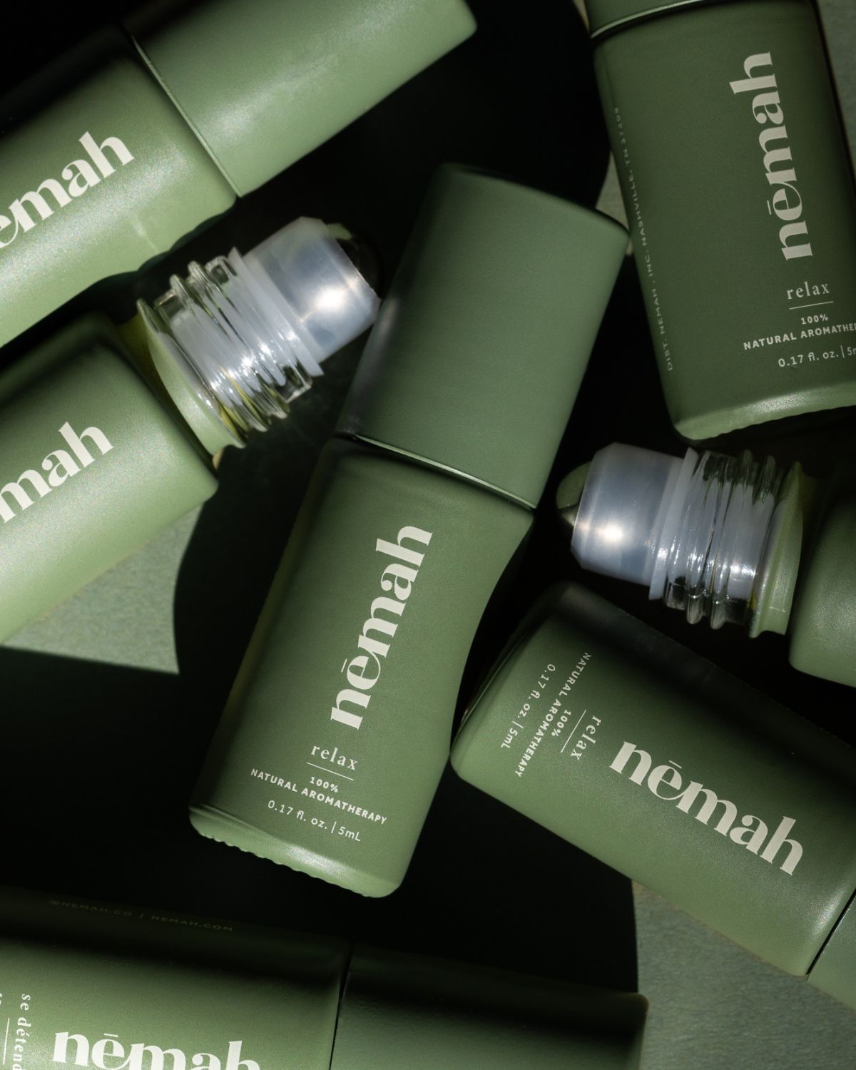 Green bottles of 'nemah' skincare products.