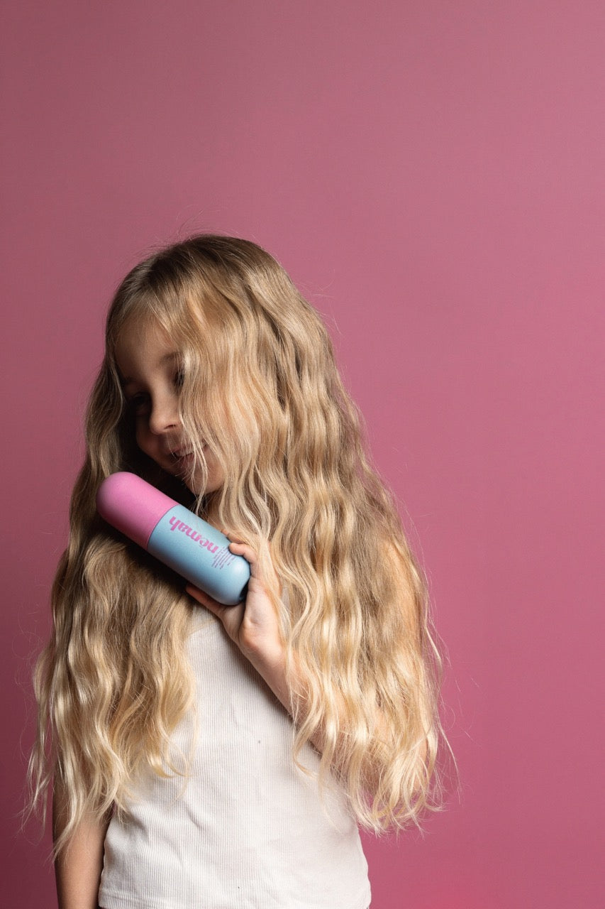 a girl with blond hair is holding a hair product 