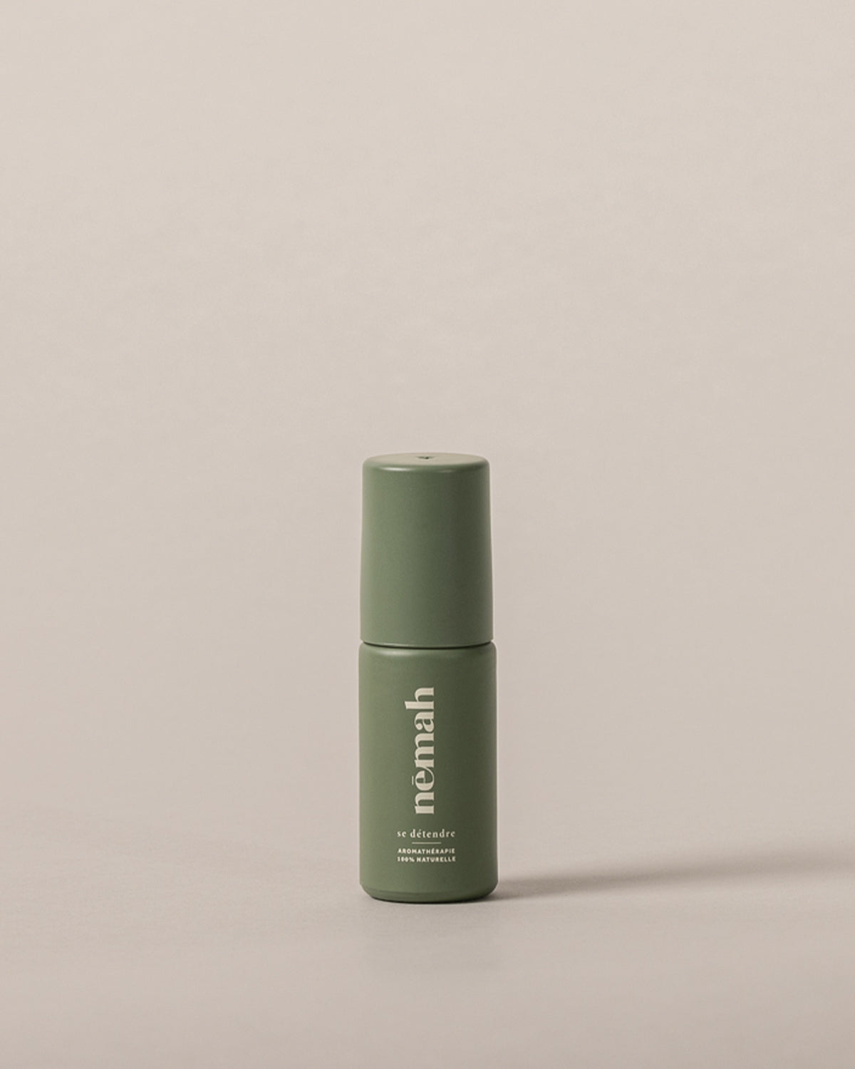 Green bottle labeled 'Nemah' against a beige background