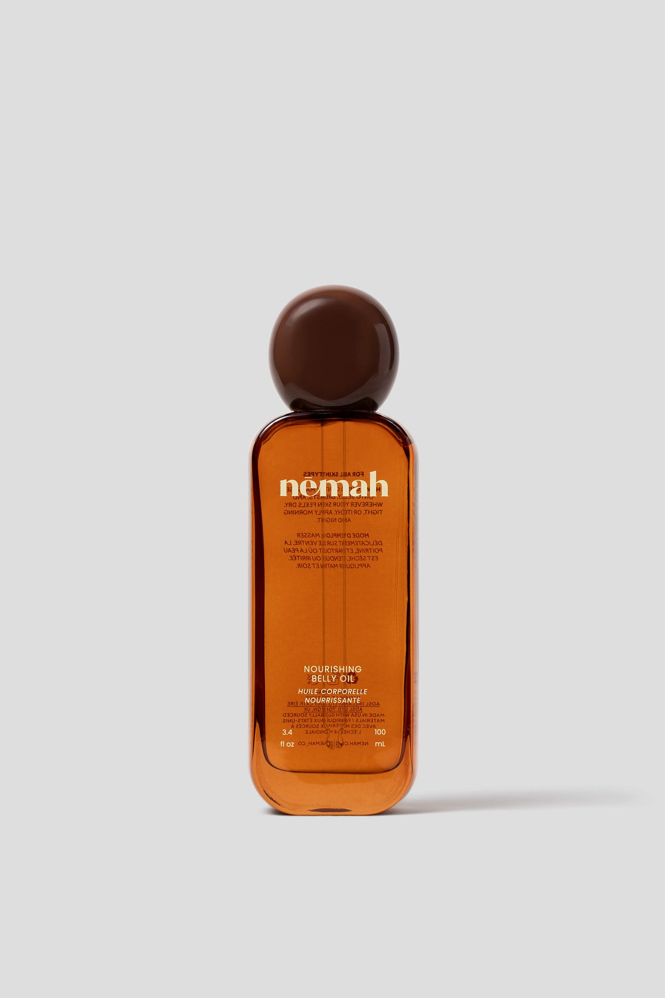 Orange bottle with a brown cap labeled 'nemah' on a white background