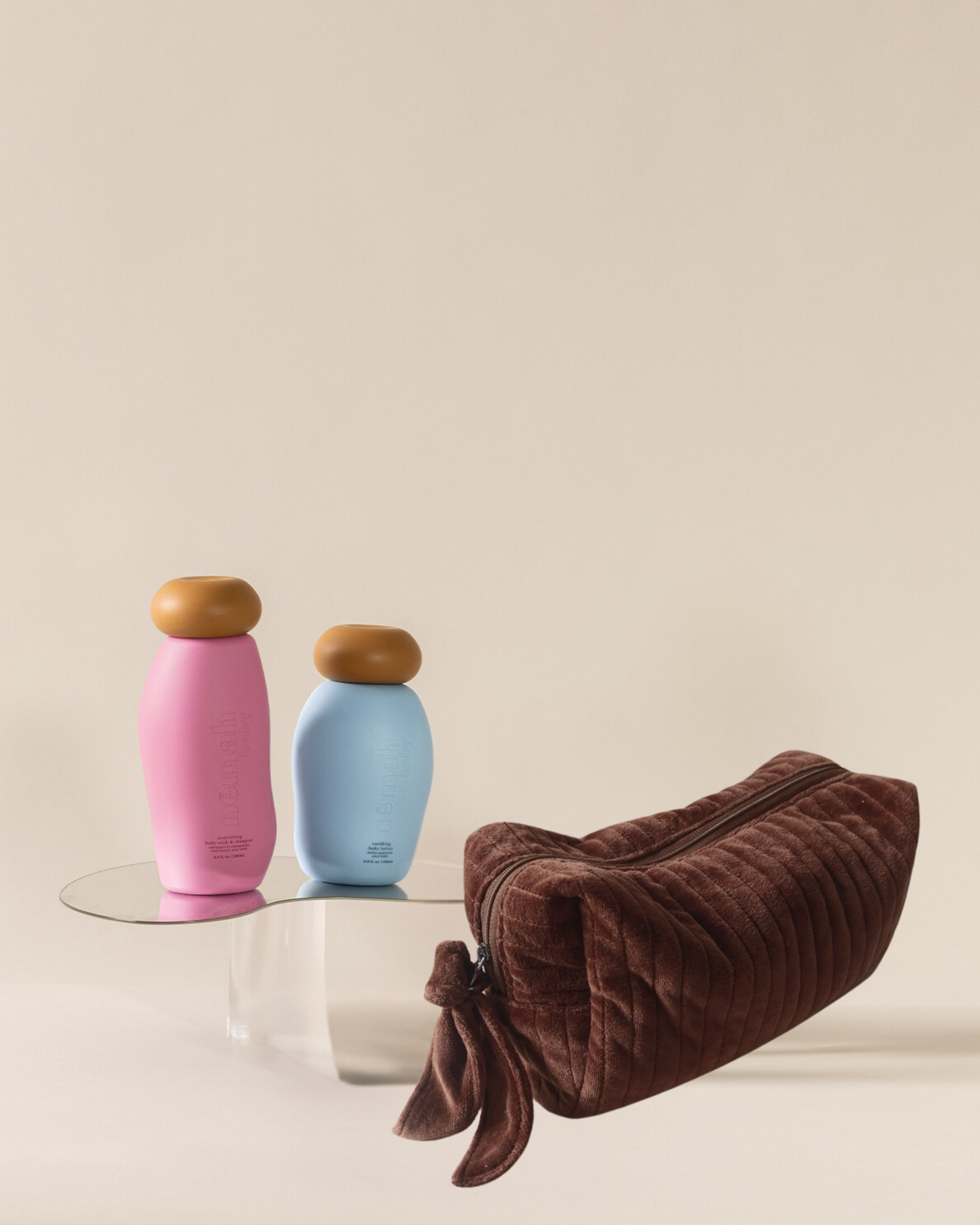 blue and pink bottles on top of glass coffee table next to a brown travel pouch 