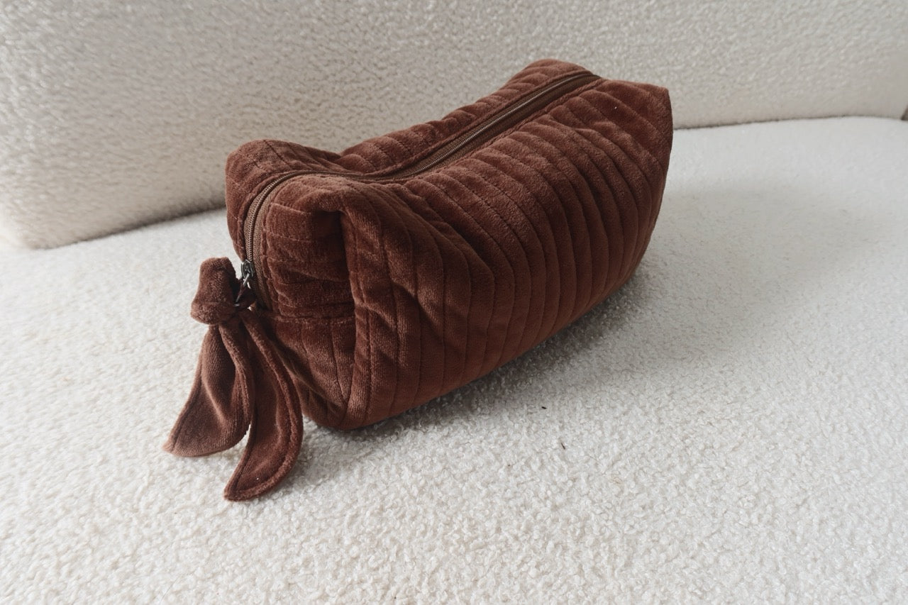 Zipped brown plush Beauty Bag on the sofa