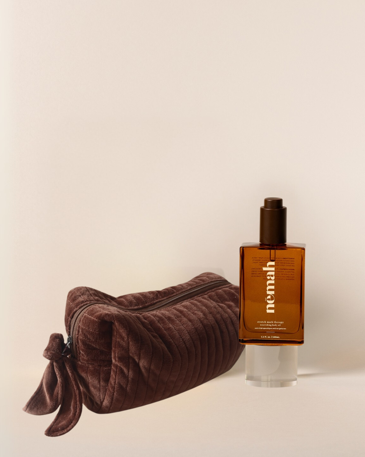 brown glass bottle with written nemah on it next to a brown plushy pouch with a zip 