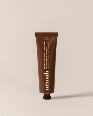 Brown tube of némah restorative scar treatment with text: "net wt. 1 oz | 30 g, restorative scar treatment, traitement réparateur des cicatrices, ANTARCTICINE®, ACTISOOTHE®, LIPOMOIST™"