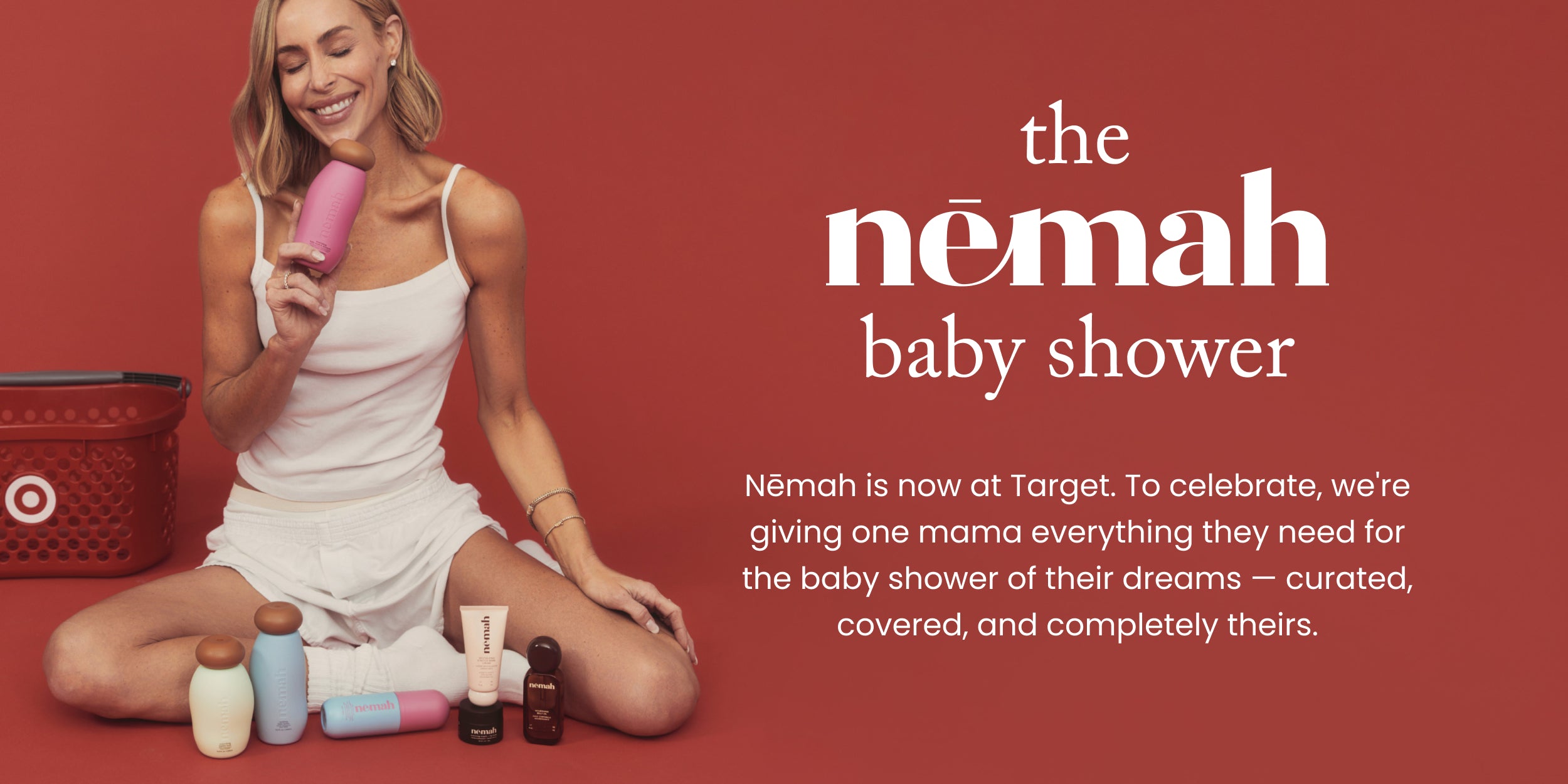 Woman holding pink Nēmah bottle with Nēmah products and Target basket on red background; headline the nēmah baby shower