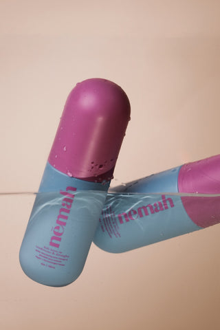 Blue-and-pink nemah kids leave-in conditioner & detangler bottle, partially submerged in water, 4oz | 118ml