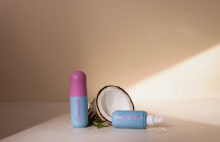 Blue roll-on and spray hair products labeled nemah beside a halved coconut