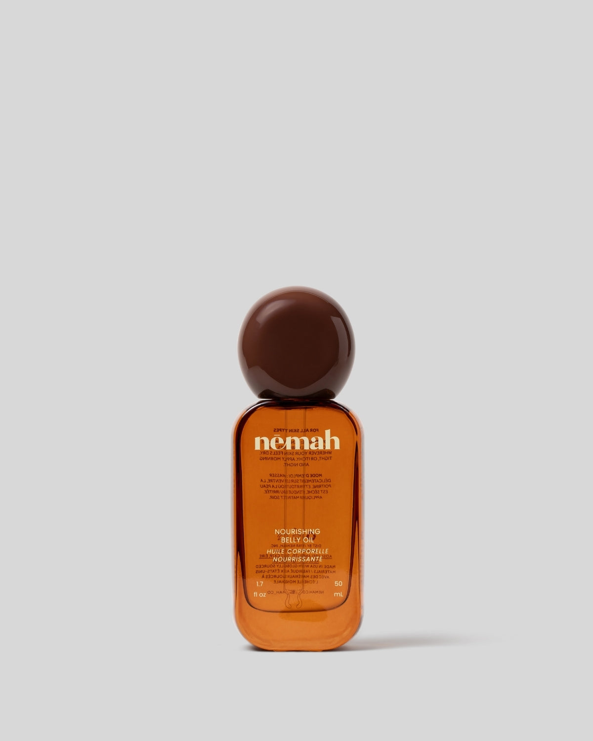 Bottle of Nemah hair oil on a light gray background