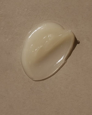 Smear of white cream or lotion on a beige textured surface