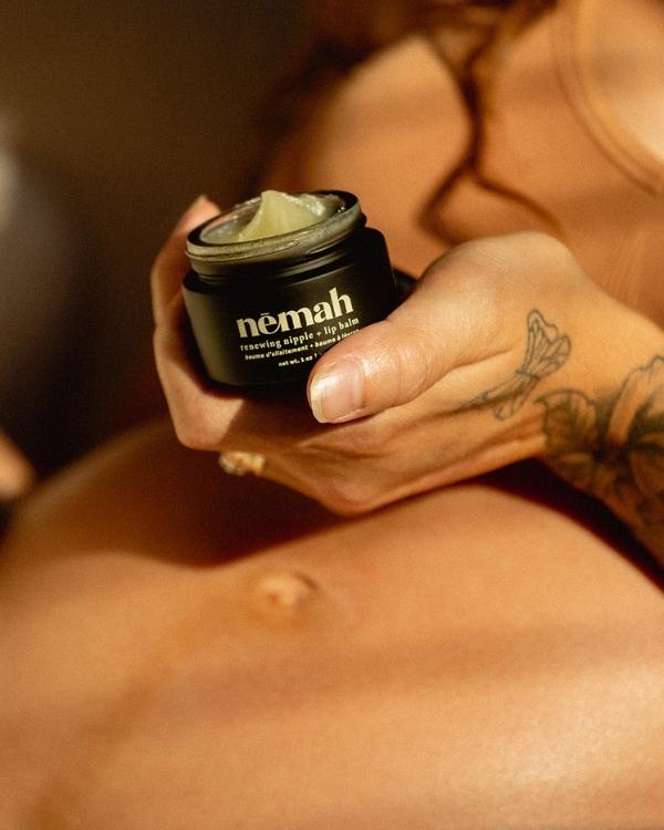 Person holding a jar of Nemah skincare cream